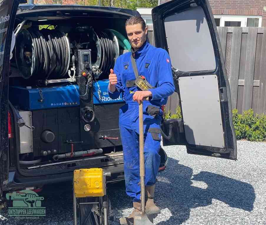 Een tevreden monteur met opgestoken duim naast de bestelbus, slim ingrijpen bespaart kosten bij een verstopte afvoer in Leeuwarden