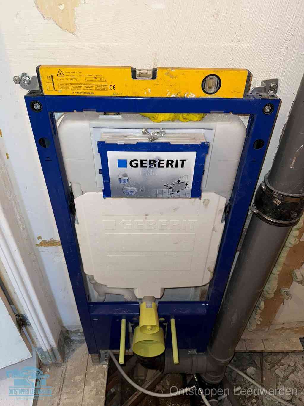 Een Geberit inbouwreservoir met frame voor een hangtoilet tegen de wand, met de afvoerbocht naar de vloer, kenmerkend voor een verstopt hangtoilet in Leeuwarden