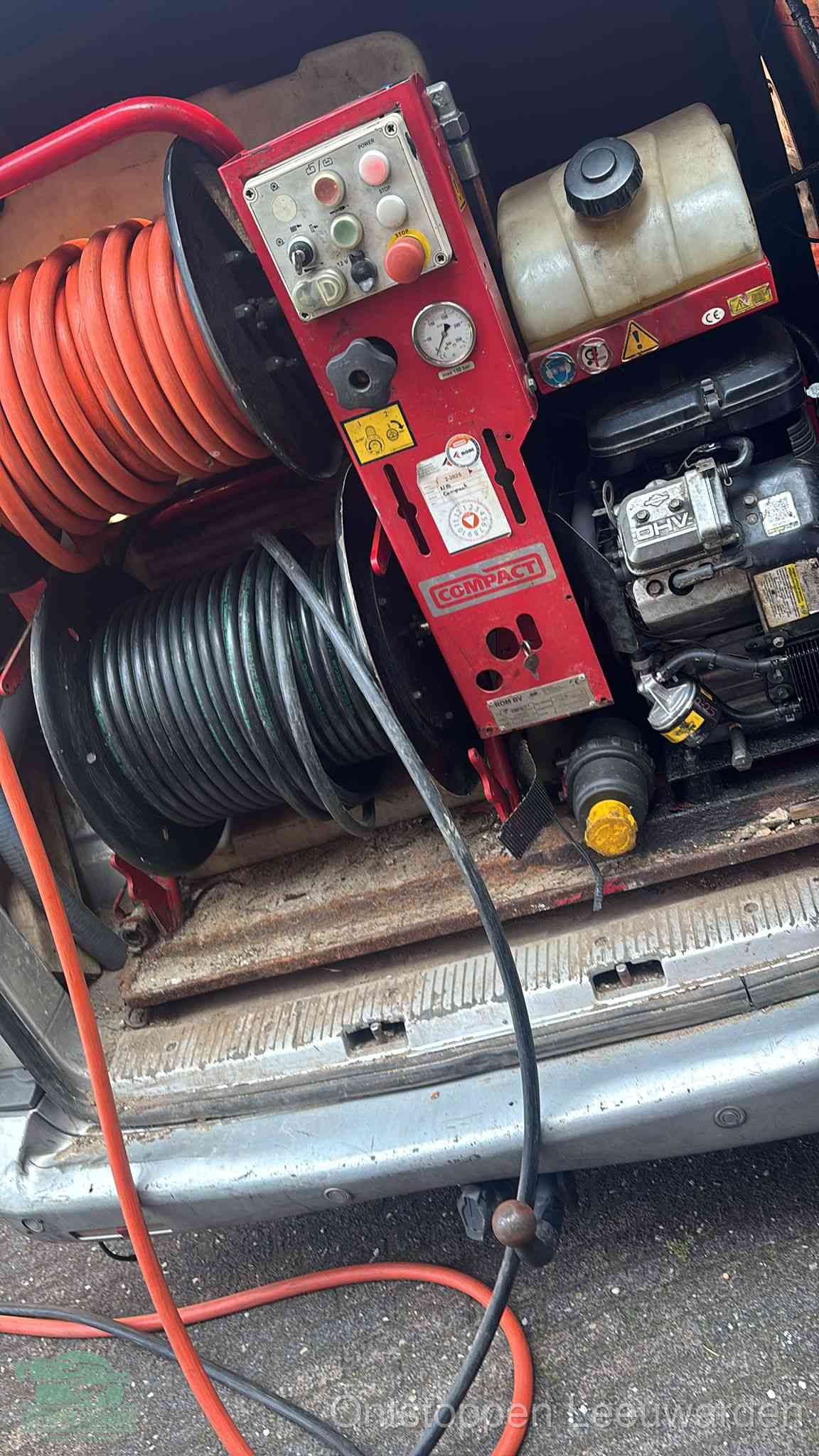Een rood hogedruk-rioolreinigingstoestel in de laadbak van de bedrijfsbus, apparatuur voor een hardnekkige afvoerverstopping in Leeuwarden