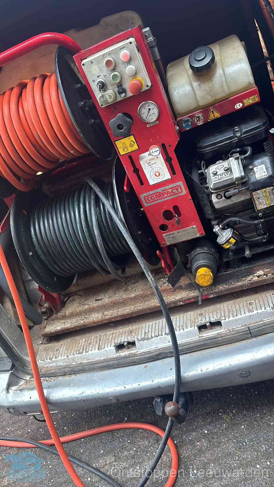 Een rood hogedruk-rioolreinigingstoestel met slangen in de laadbak van de bedrijfsbus, apparatuur voor een hardnekkige wc-verstopping in Leeuwarden