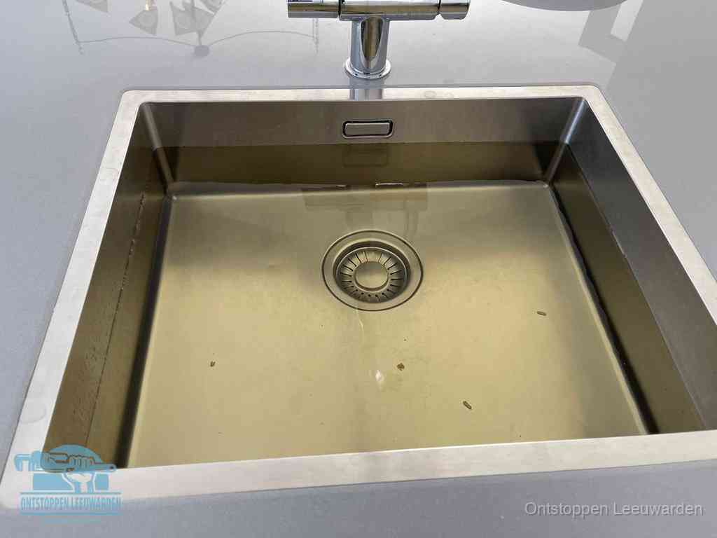 Stilstaand water in een rvs spoelbak dat niet wegloopt, een duidelijk signaal van een gootsteenverstopping in Leeuwarden